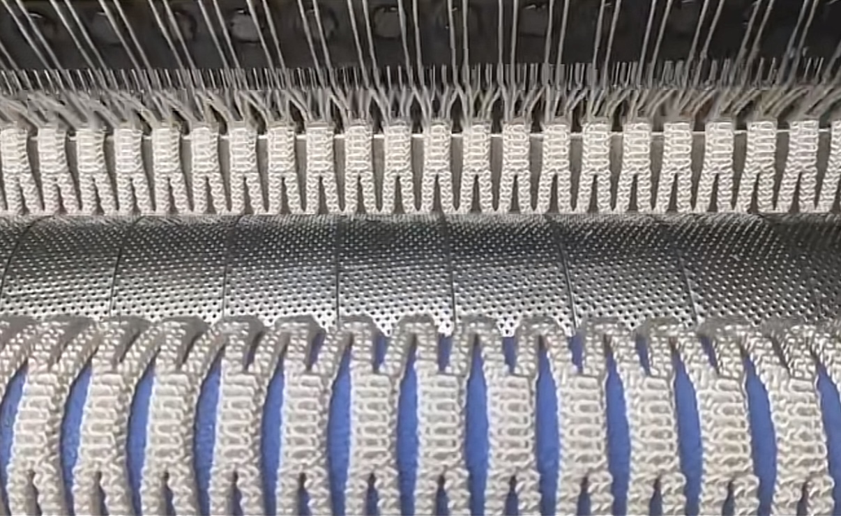 Máquina de tejer urdimbre de red de pesca formando malla durante la producción